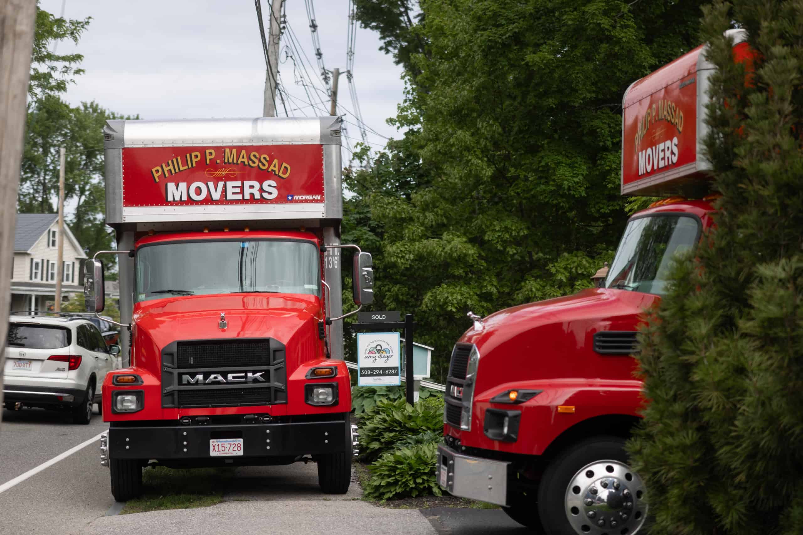 Two red trucks parked on the side of the road.